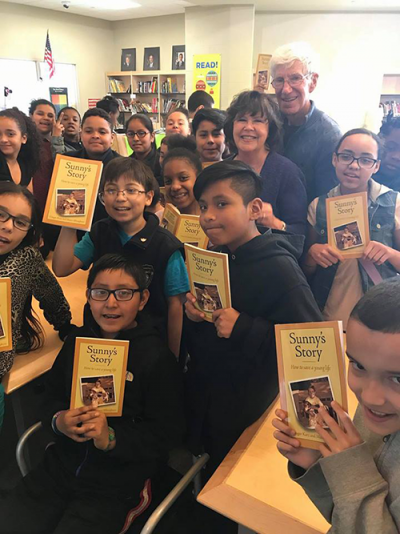 Elementary kids hold up copies of our substance use prevention book Sunny's Story.