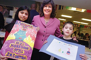 Ginger with students holding artwork